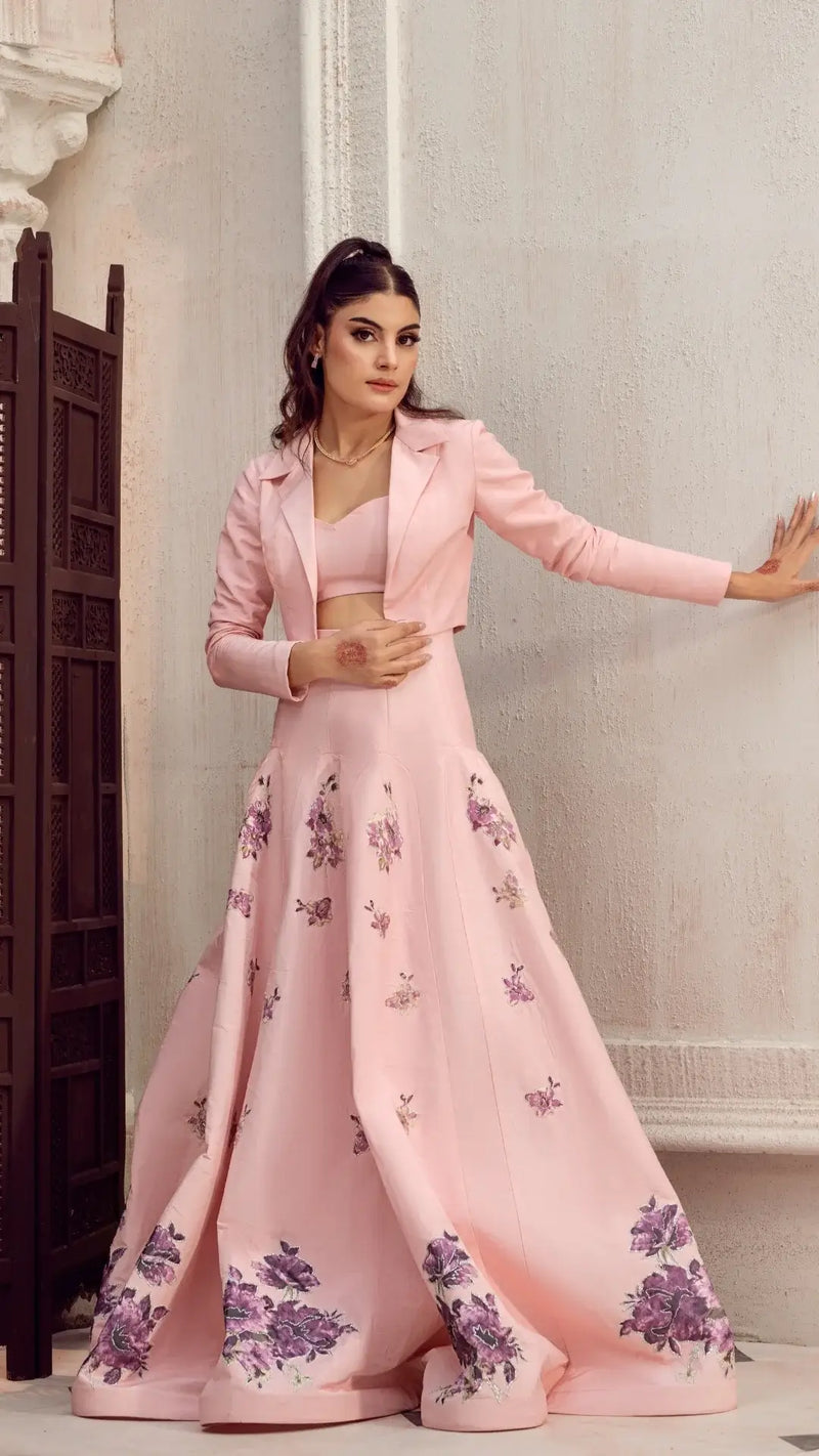 Woman wearing elegant light pink formal dress with floral embroidery and cropped blazer