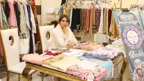Woman sitting at a table with fabric samples in a fabric store.