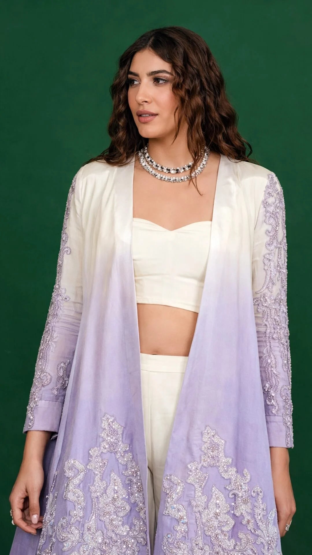 Woman wearing a white blouse and lavender embroidered dupatta against a green background