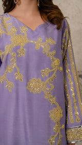 Purple outfit with gold embroidery on a neutral background