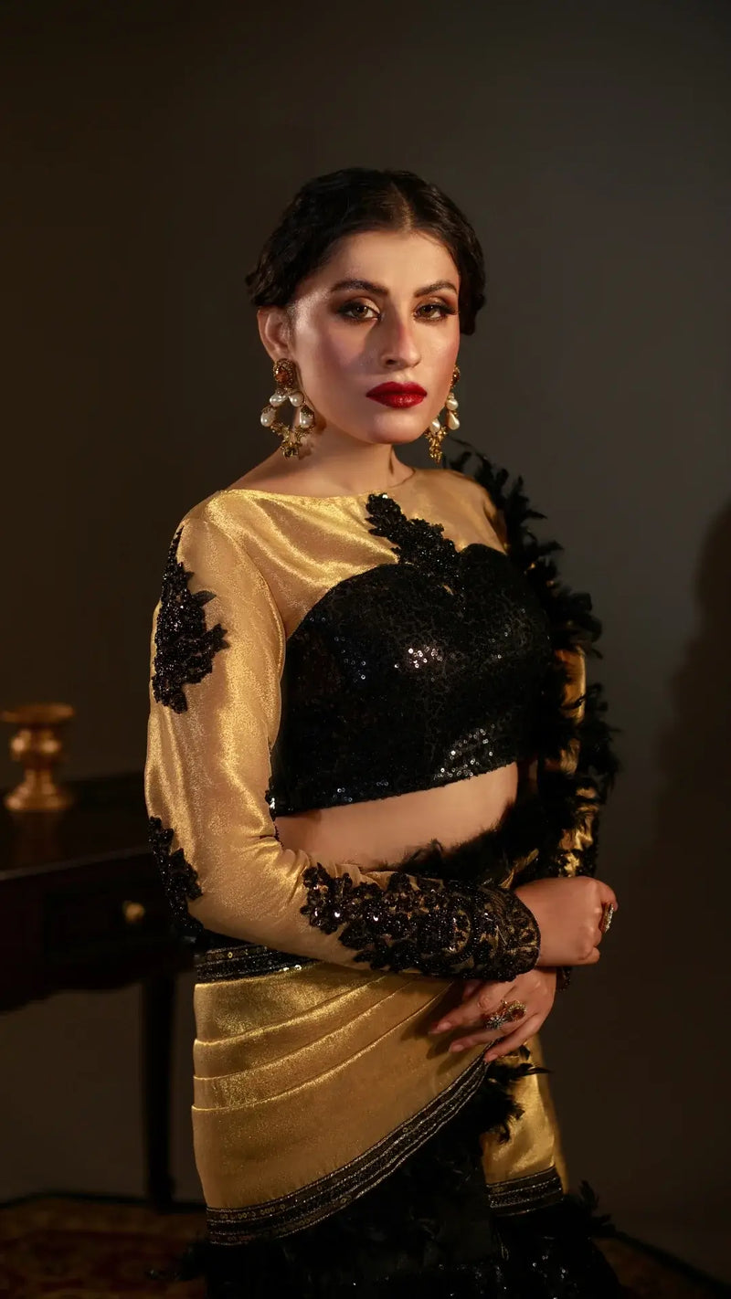 Woman wearing a gold and black traditional outfit with a dark background