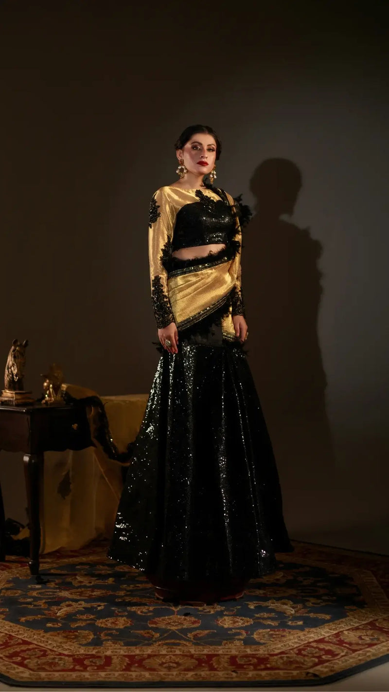 Woman wearing a black and gold traditional outfit in a dimly lit room.