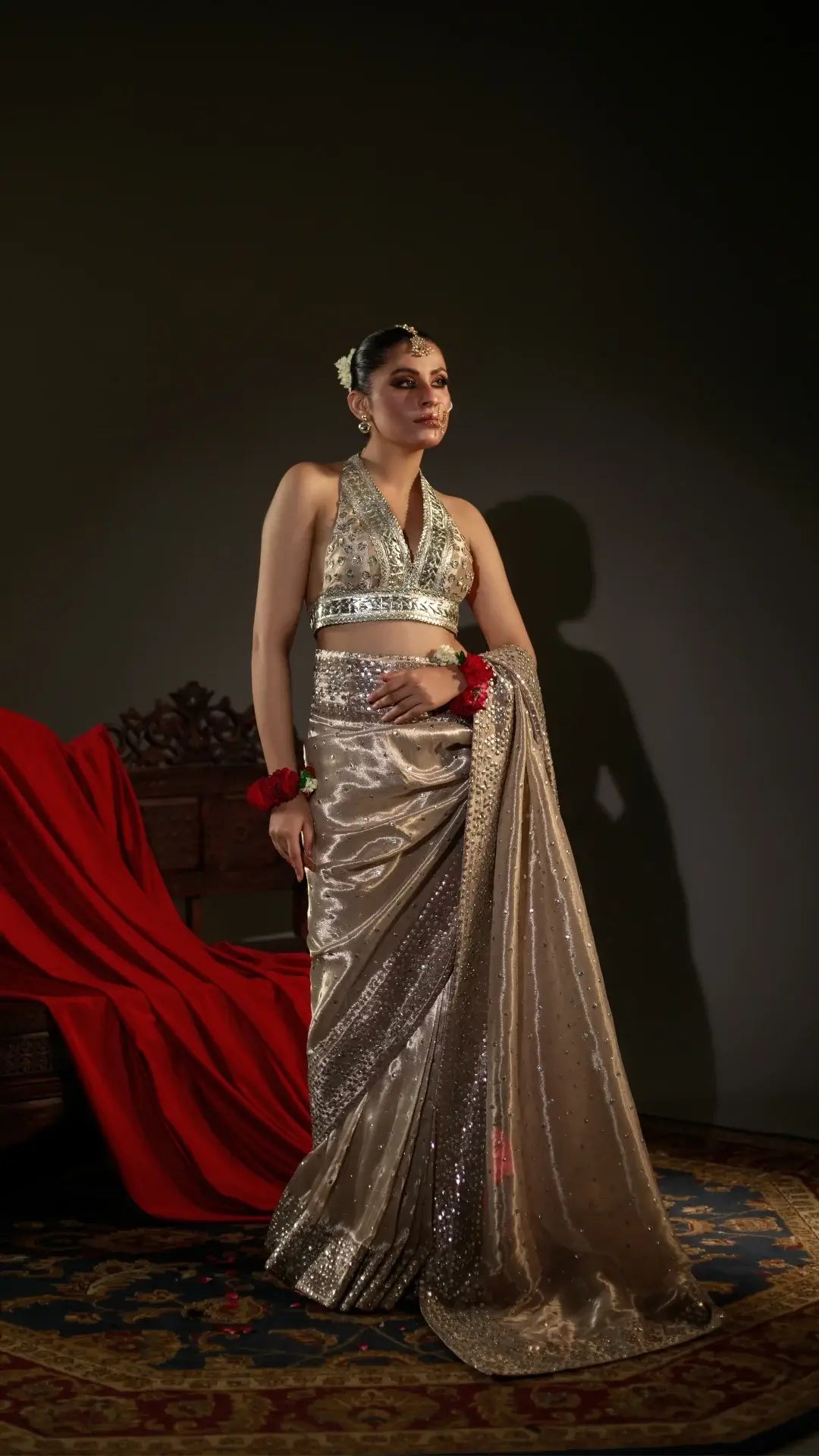 Woman in a sparkling silver saree with a dark background