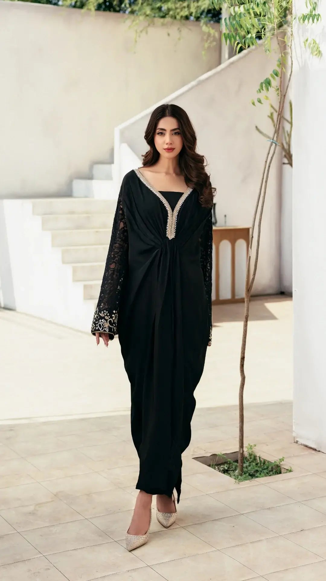 Woman in a black dress standing in a modern indoor setting