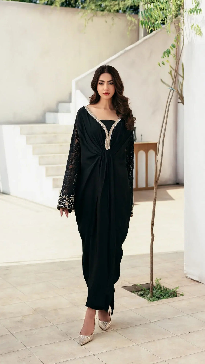Woman in a black dress standing in a modern indoor setting
