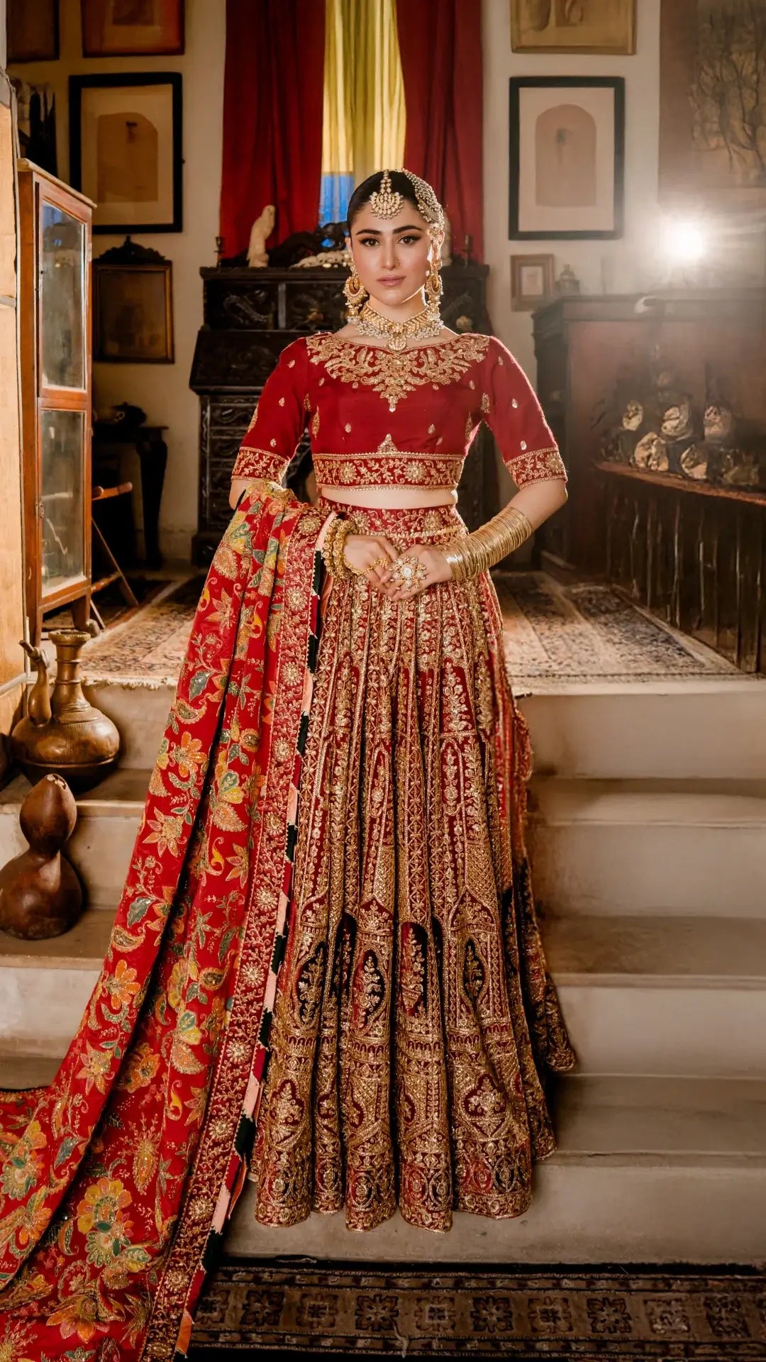 Woman in traditional red and gold embroidered outfit standing on a staircase.