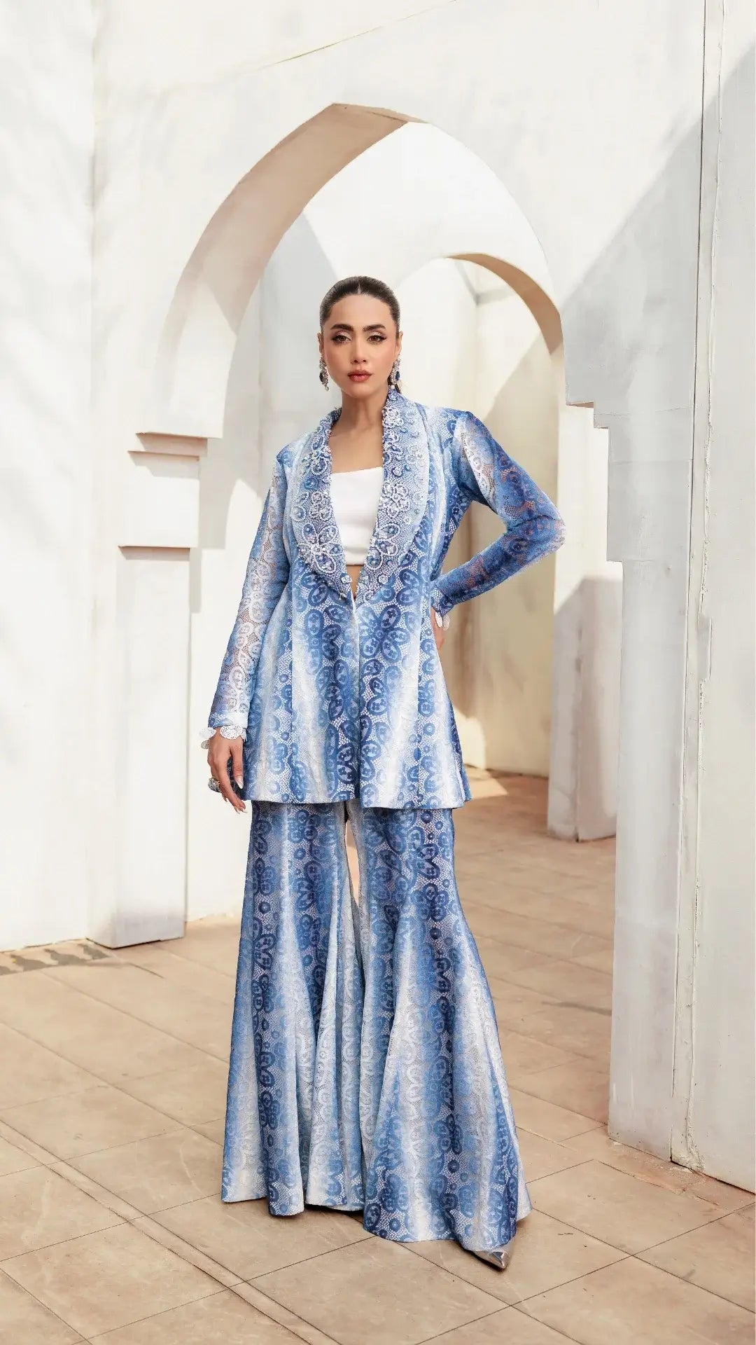 Woman wearing a blue patterned outfit in an elegant interior setting