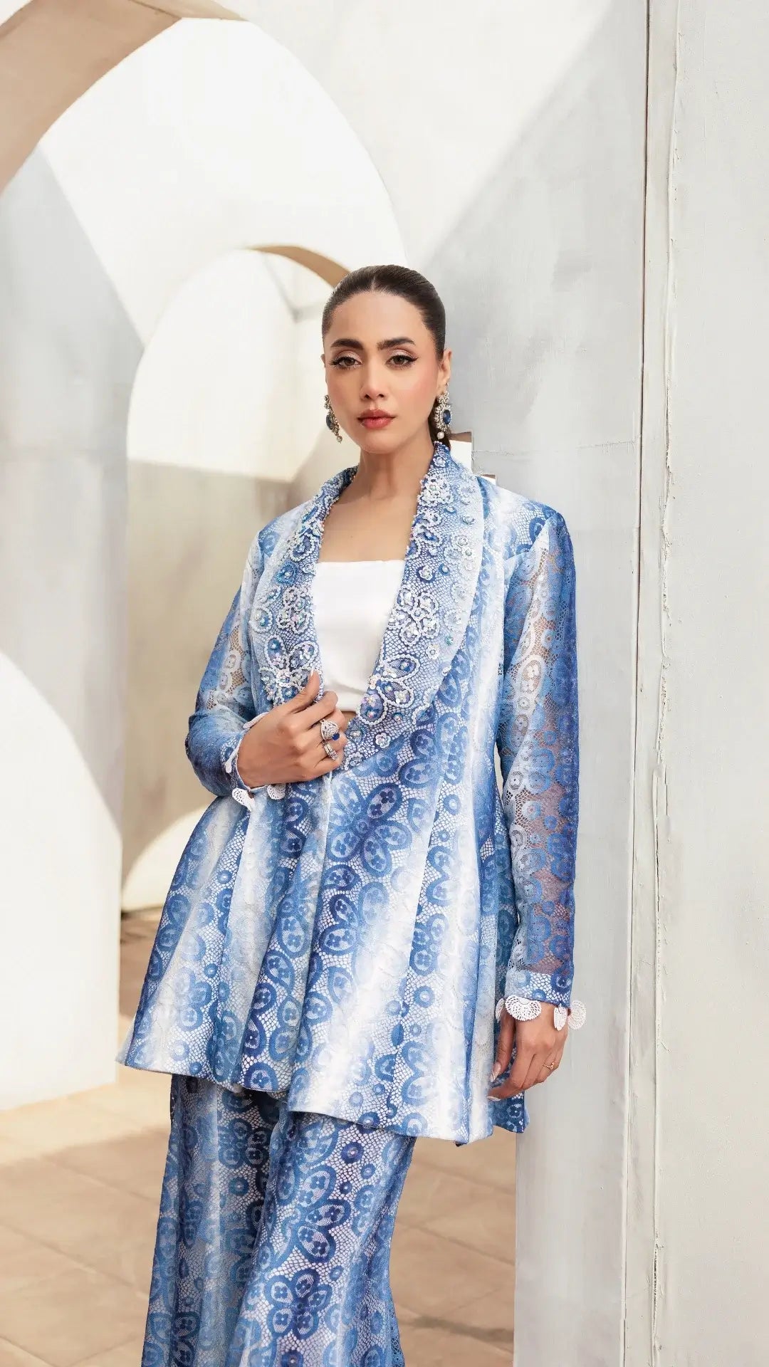 Woman wearing a blue and white patterned outfit in a modern interior setting