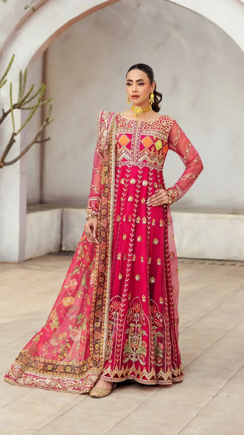 Woman wearing a traditional pink embroidered outfit in an outdoor setting.