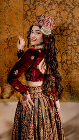 Woman in maroon and gold velvet lehenga with traditional Pakistani bridal jewelry