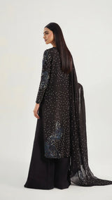Woman wearing a black outfit with sequin details on a white background