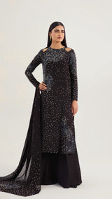 Woman wearing a black outfit with silver embellishments on a white background