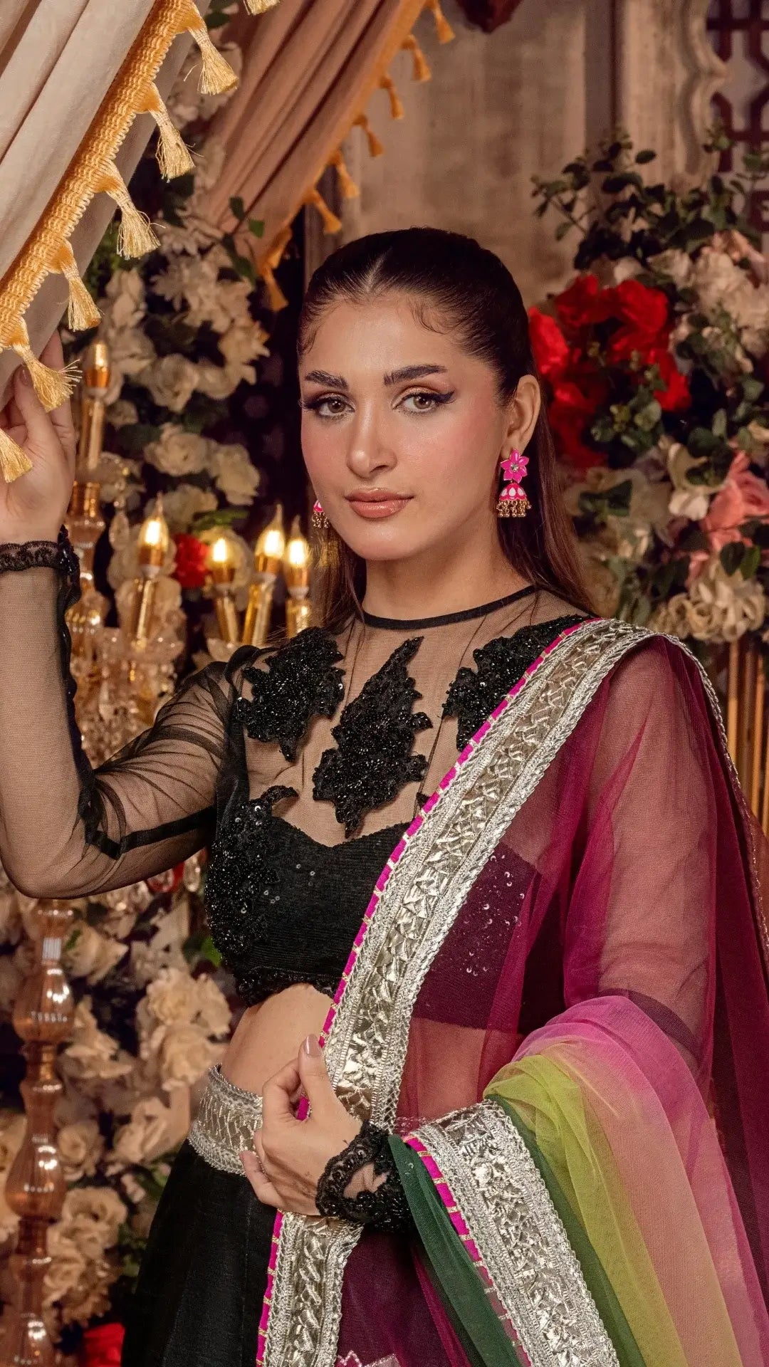 Woman in traditional attire with floral decorations in the background