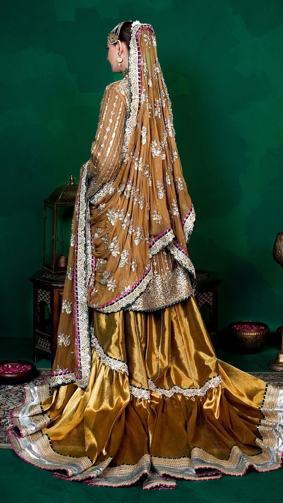 Traditional gold and white embroidered saree with a green background