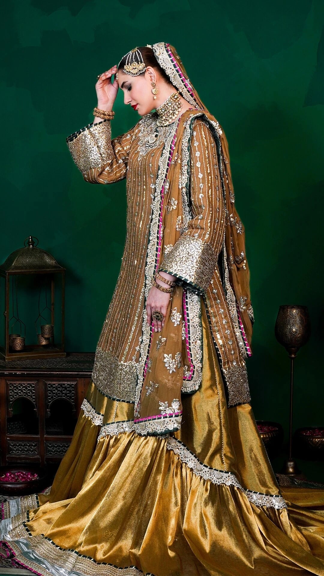 Traditional embroidered outfit with intricate designs on a dark green background