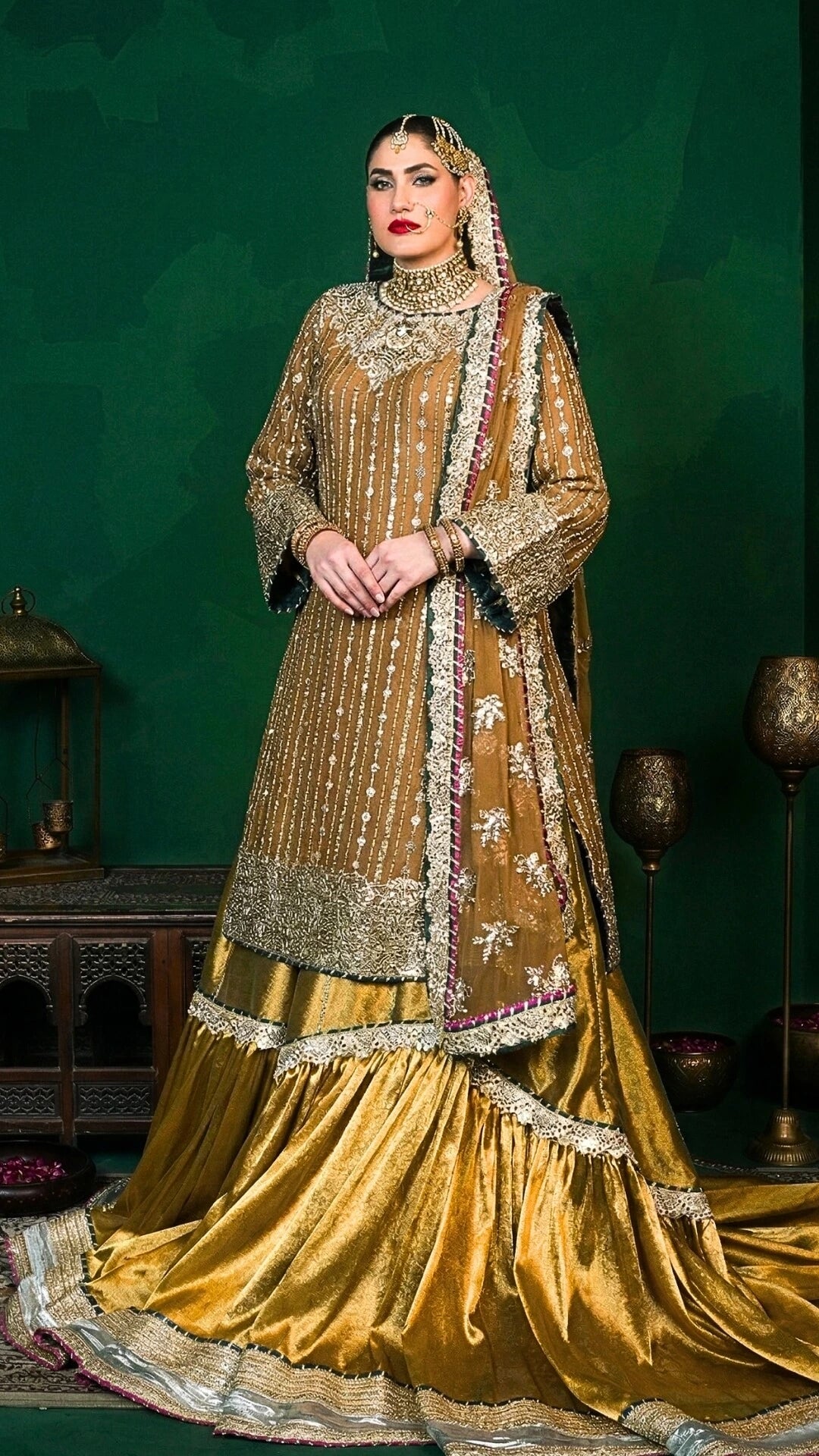 Woman in a traditional embroidered gold outfit against a green background
