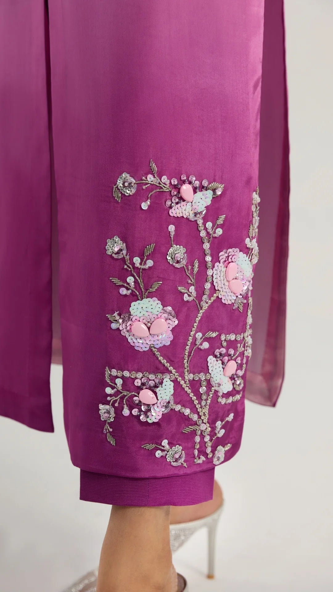 Purple garment with floral embroidery on a white background