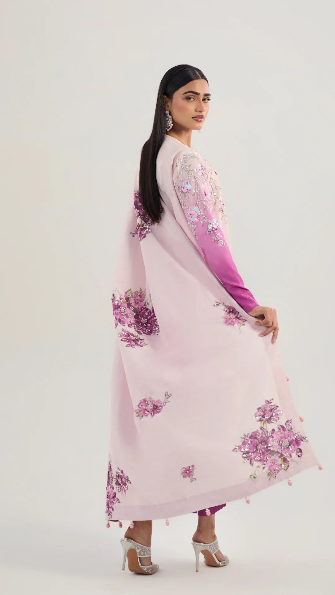 Woman wearing a pink floral dress with a gradient effect on a white background