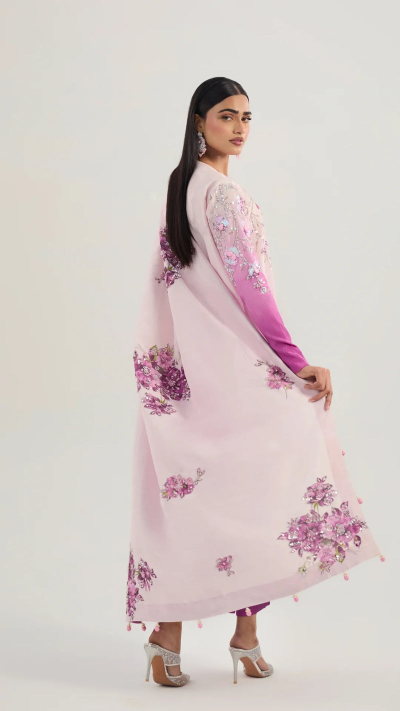 Woman wearing a pink floral dress with a gradient effect on a white background