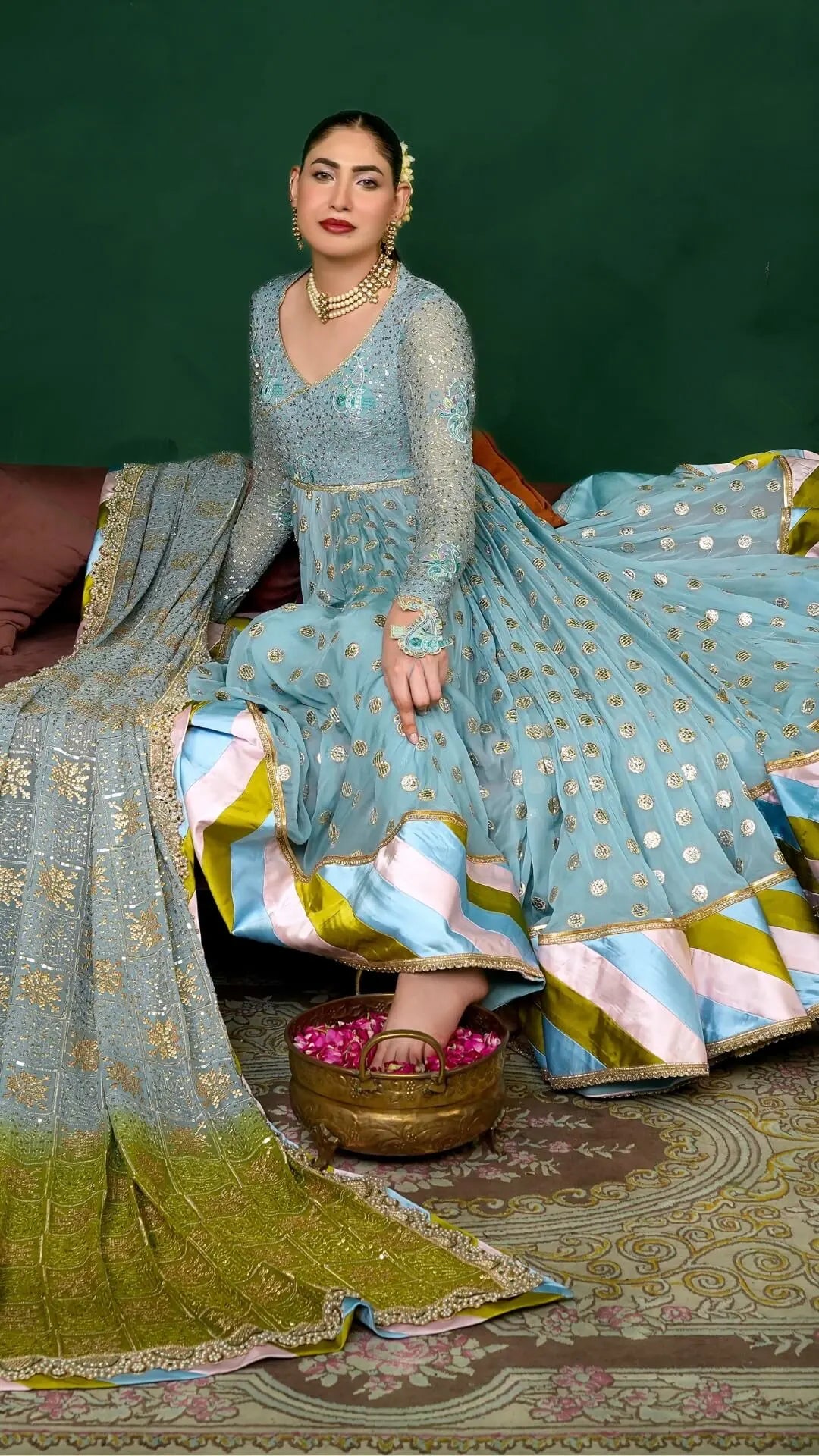 Woman in traditional attire with a green background