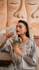 Woman holding flowers in front of a Buddha statue