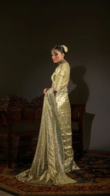 Woman in a gold traditional outfit with a dark background