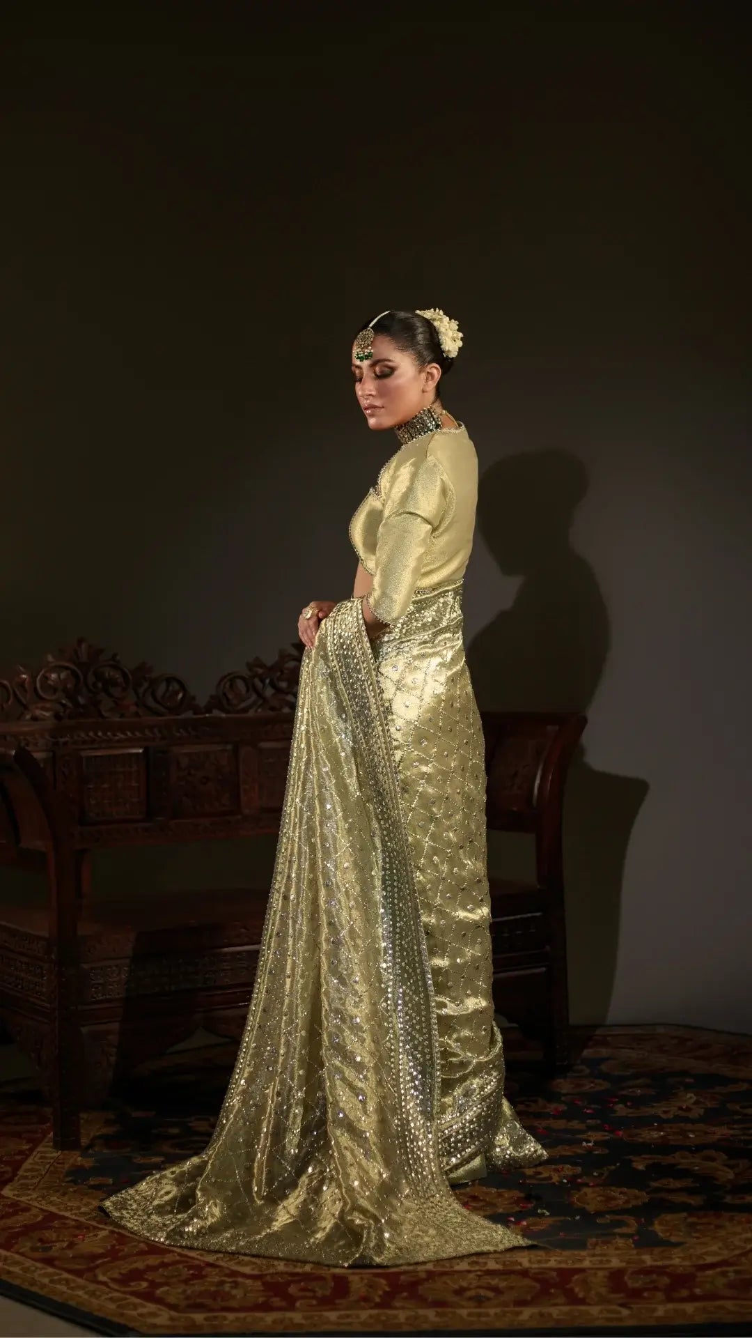 Woman in a gold traditional outfit with a dark background