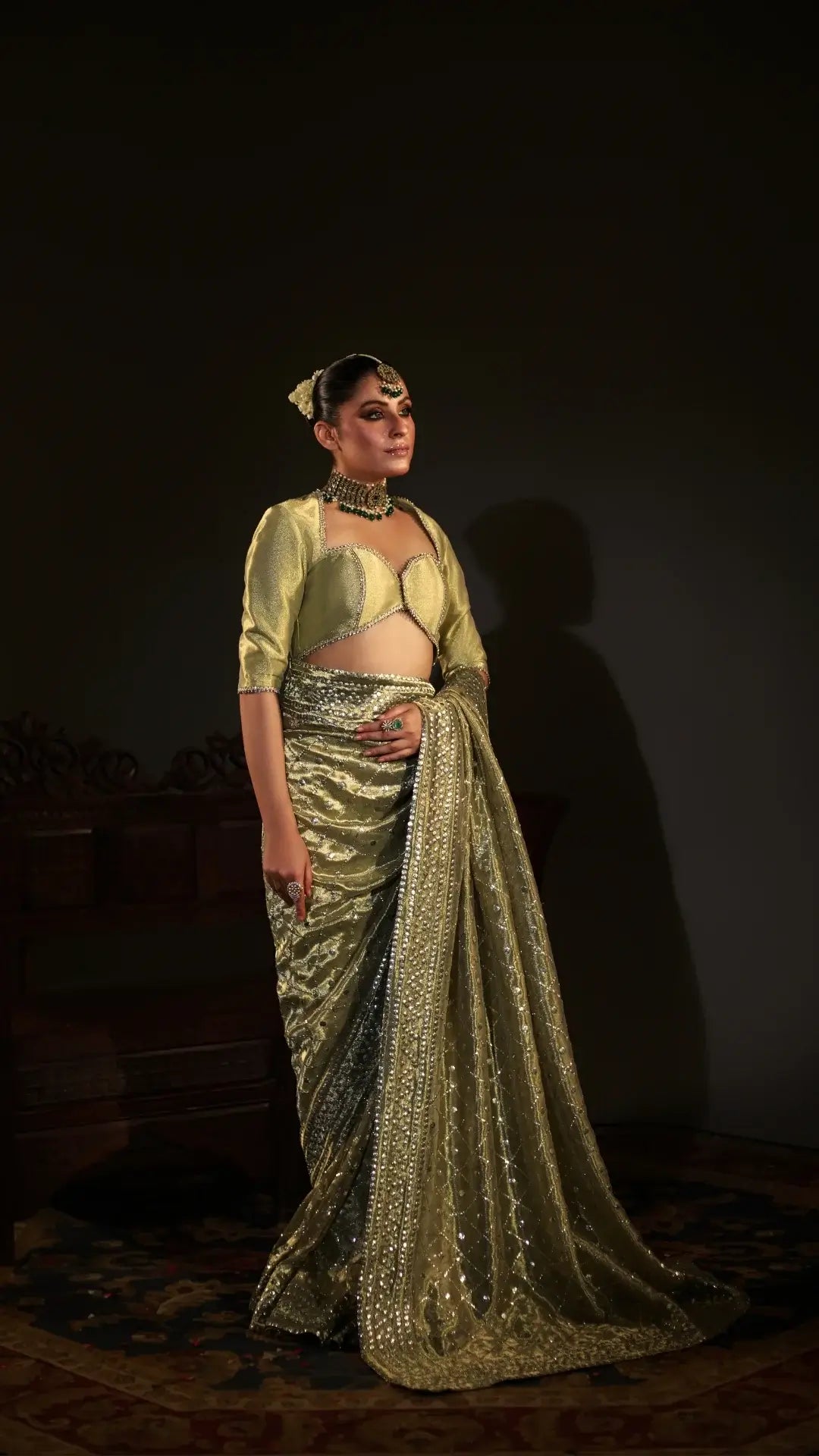 Woman in a gold saree with a dark background