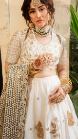 Woman wearing a traditional outfit with intricate jewelry and embroidery.